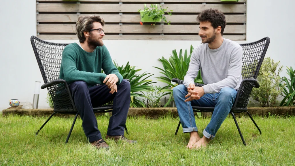 Two people talking, one leaning in and actively listening